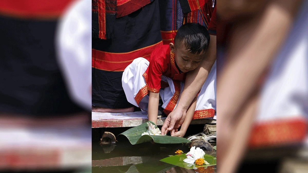 পানিতে ফুল ভাসাচ্ছে শিশুটি