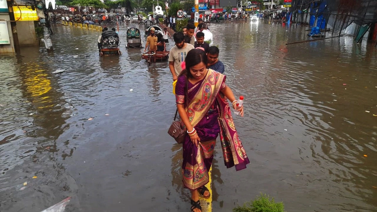 সড়কের জলাবদ্ধতায় রাস্তার ডিভাইডার দিয়ে পার হচ্ছেন পথচারীরা