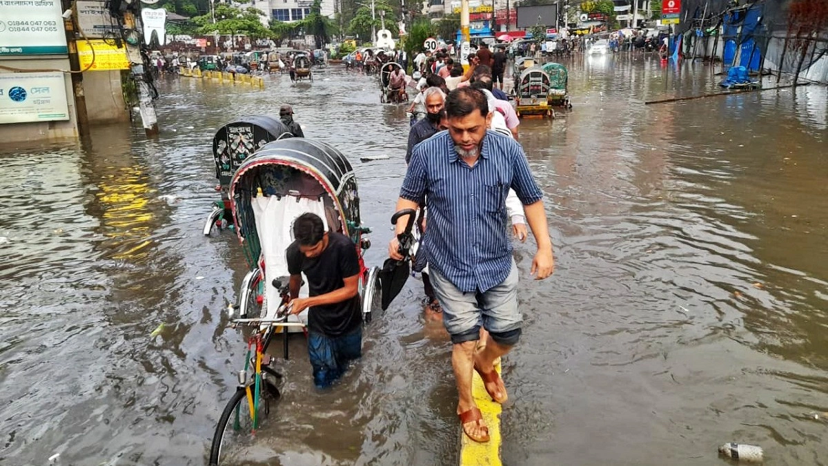 সড়কের জলাবদ্ধতায় রাস্তার ডিভাইডার দিয়ে পার হচ্ছেন পথচারীরা