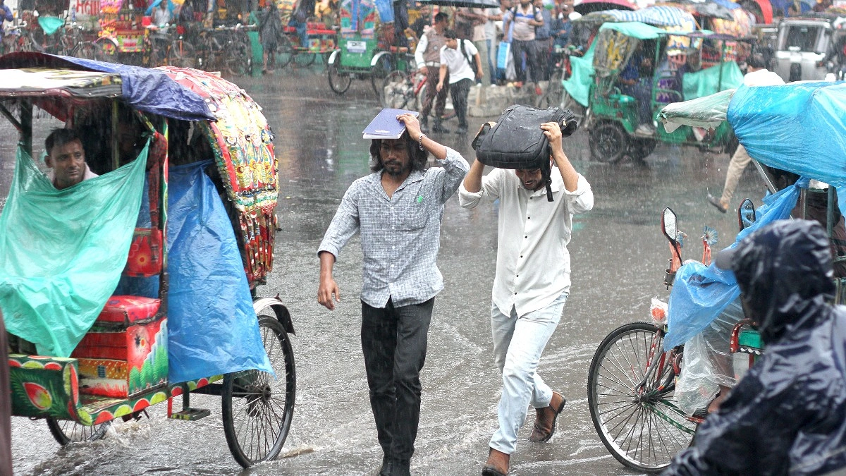 বৃষ্টি থেকে রক্ষা পেতে খাতা, ব্যাগ মাথায় ছুটছেন পথচারীরা।