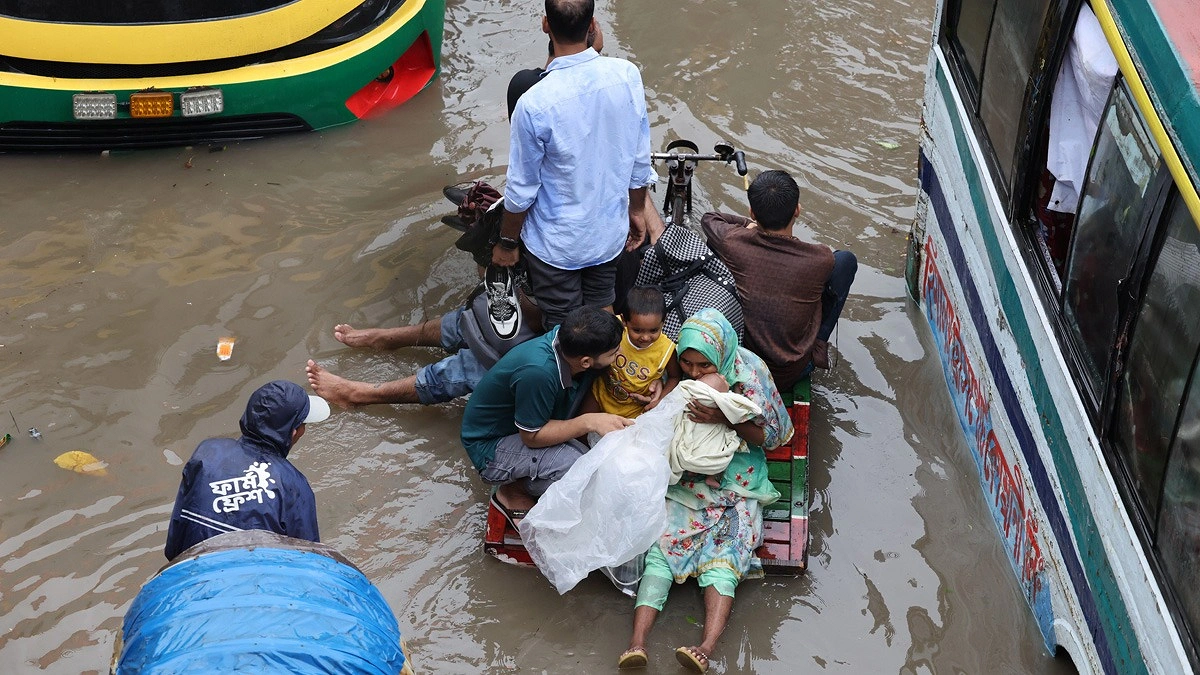 সড়কে জলাবদ্ধতায় ভ্যানে করে পারাপার। ছবিটি আরামবাগ এলাকা থেকে তোলা—মহুবার রহমান