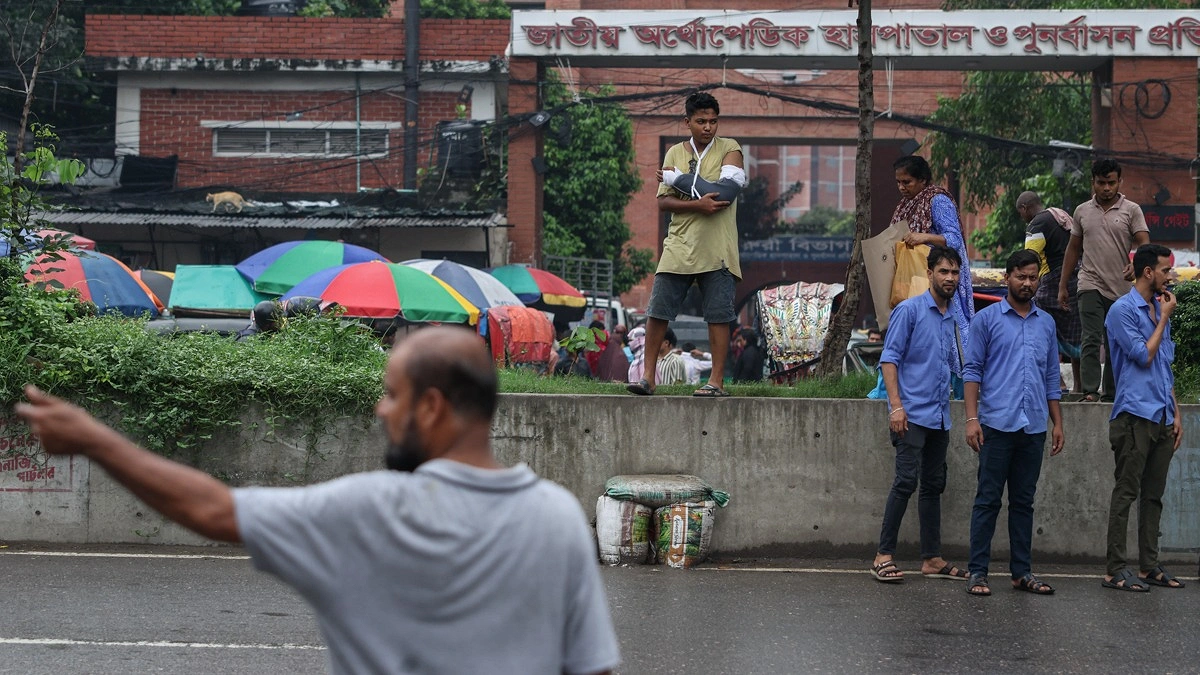 হাতে প্লাস্টার নিয়ে রাস্তা পার হতে রোড ডিভাইডারে উঠেছেন একজন রোগী