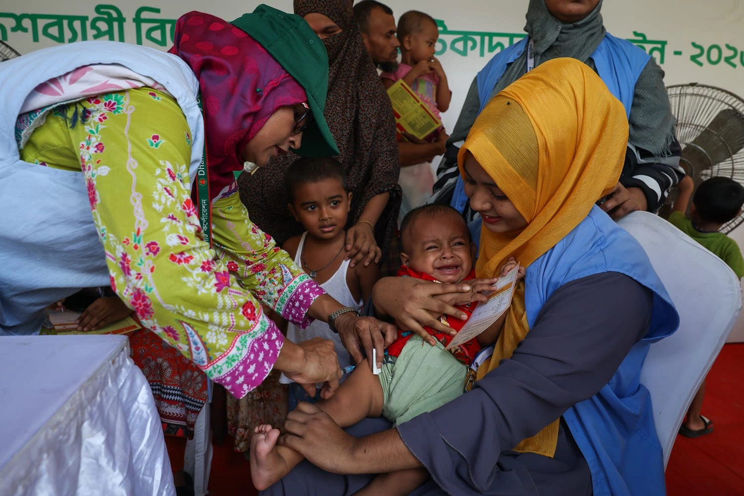 রাজধানীর কড়াইলের টিএন্ডটি খেলার মাঠে টিকা দেওয়া হচ্ছে এক শিশুকে। ছবি: শামীম-উস-সালেহীন