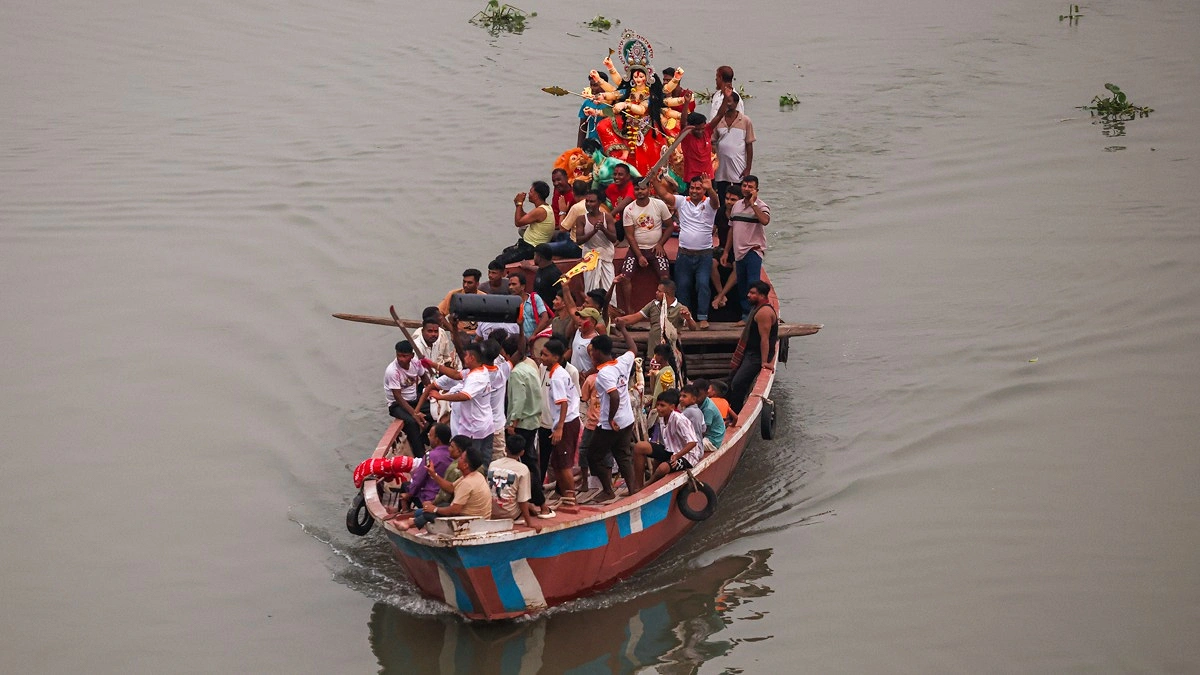 নৌকায় করে আনা হচ্ছে প্রতিমা