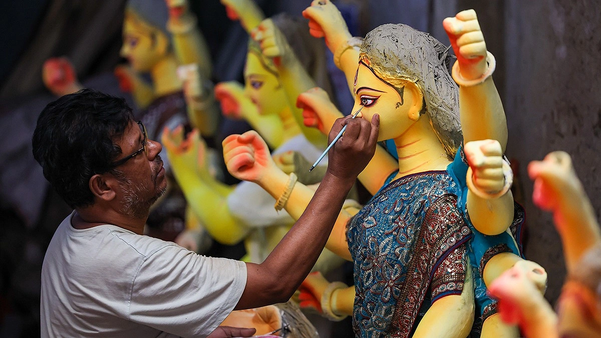 দেবী দুর্গার চোখ আঁকছেন শিল্পী।
