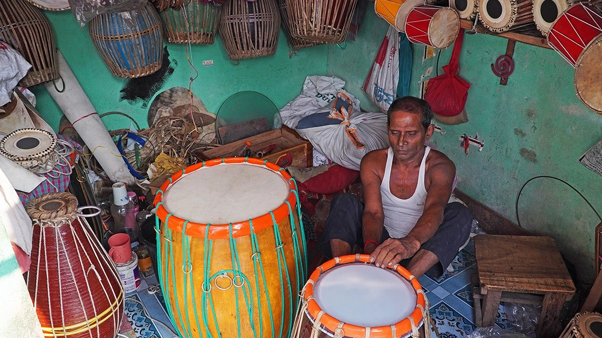 দুর্গাপূজার উৎসবকে সামনে রেখে নতুন ঢোল তৈরি এবং পুরনো ঢোল সংস্কারের কাজে ব্যস্ত কারিগর।