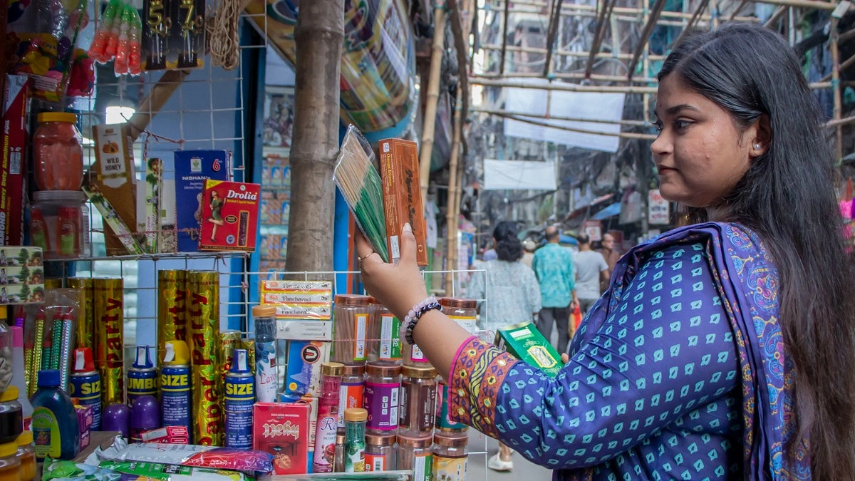 পূজার আচার-অনুষ্ঠানের জন্য প্রয়োজনীয় ধূপ ও সুগন্ধি সামগ্রী কিনছেন এক তরুণী।