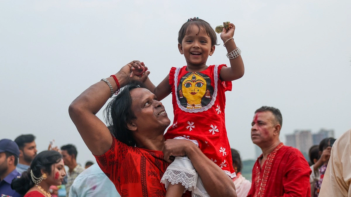 প্রতিমা বিসর্জন দেখতে এসে উচ্ছ্বসিত এক শিশু