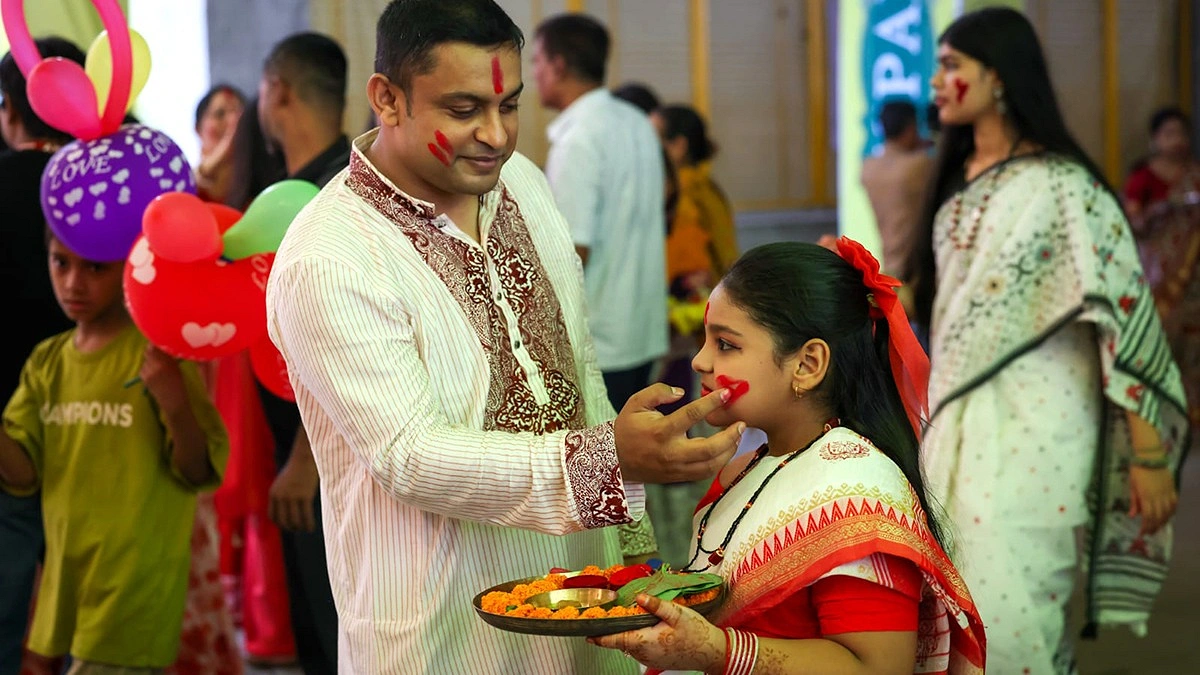 শিশুর গালে সিঁদুর মাখানো হচ্ছে।