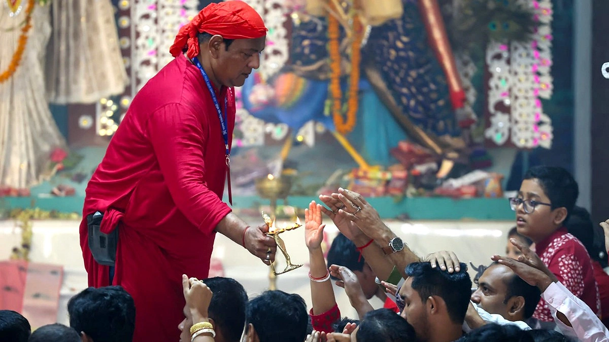 প্রদীপের পবিত্র ধোঁয়া নেওয়া হচ্ছে।