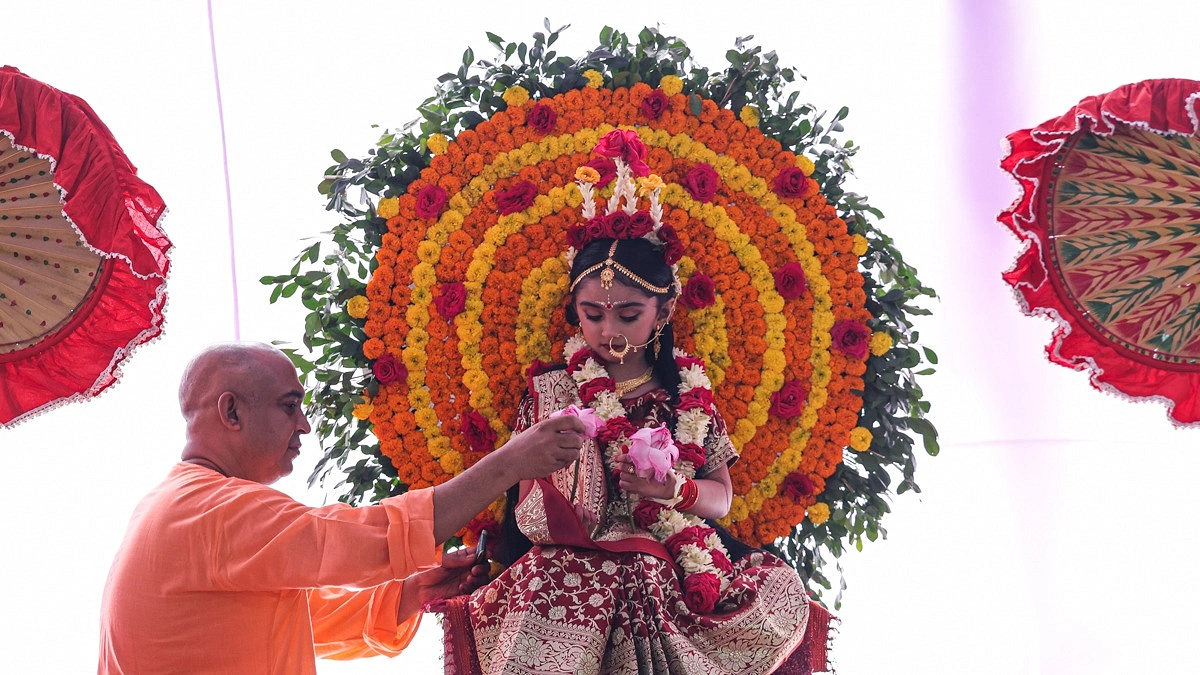 কুমারী পূজার আনুষ্ঠানিকতার অংশ হিসেবে কুমারীর হাতে দেওয়া হচ্ছে পদ্মফুল